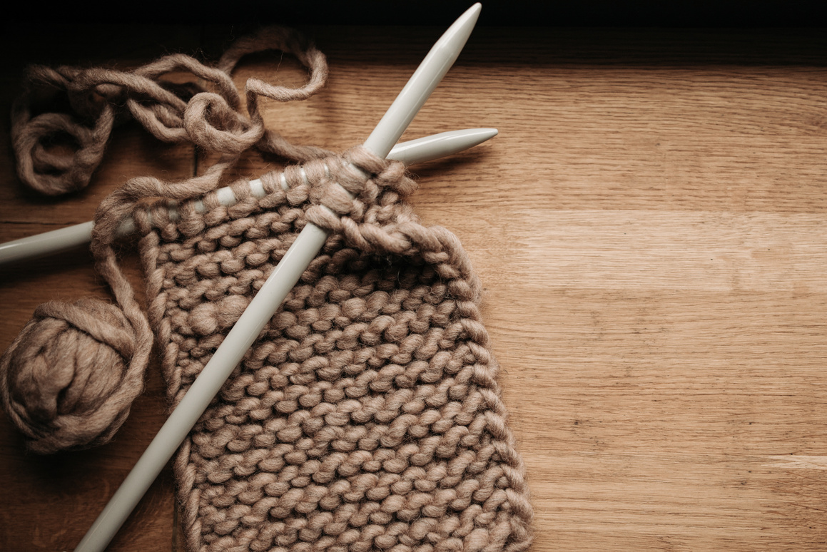 Knitting Needles and Yarn on Wooden Surface